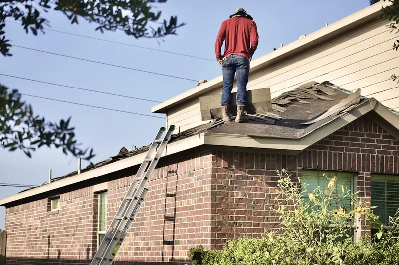 Professional roofer working on a residential roof in Willow Manor